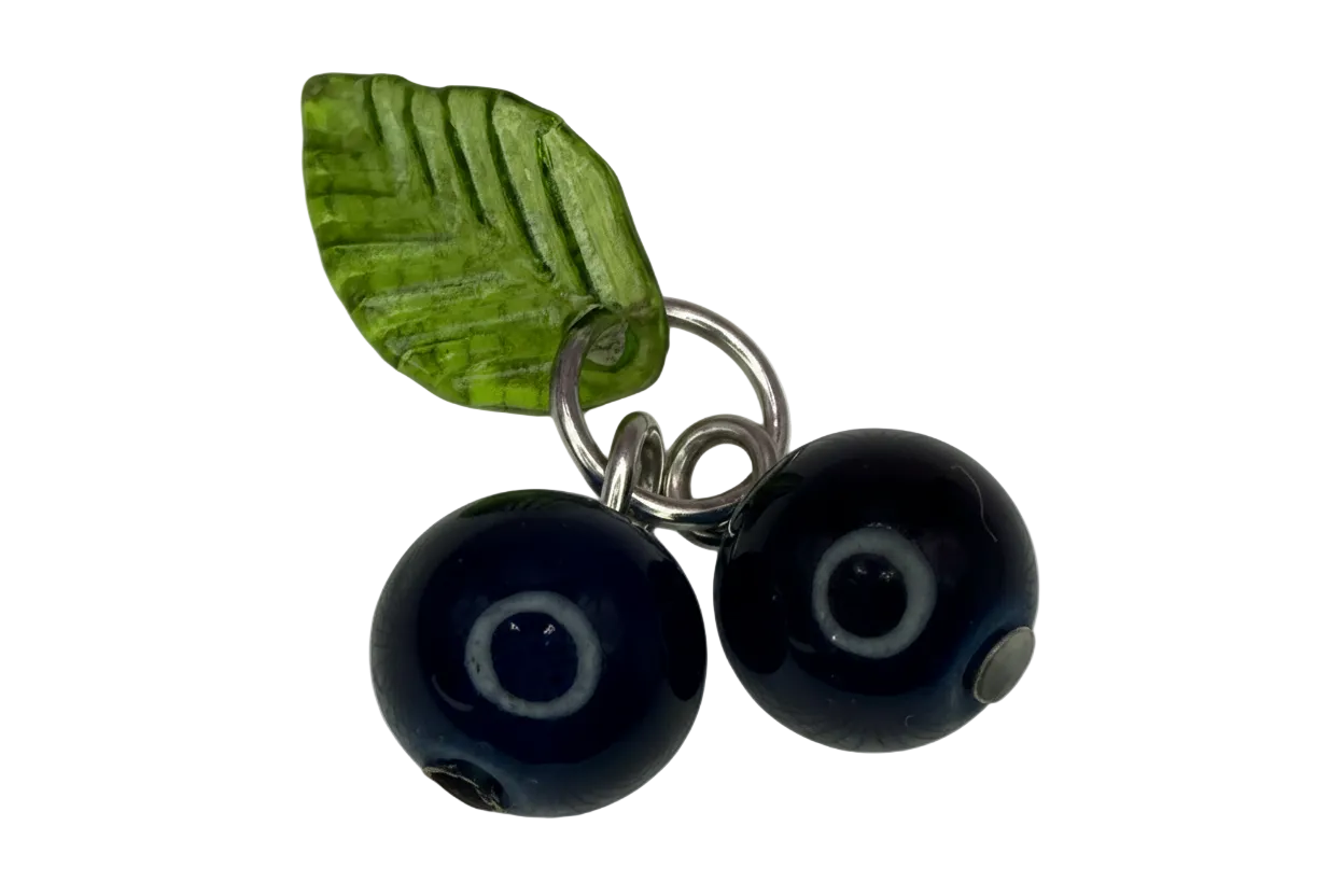 Silver charm with two navy evil-eye glass beads and a translucent green leaf accent
