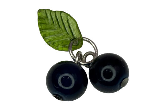 Silver charm with two navy evil-eye glass beads and a translucent green leaf accent