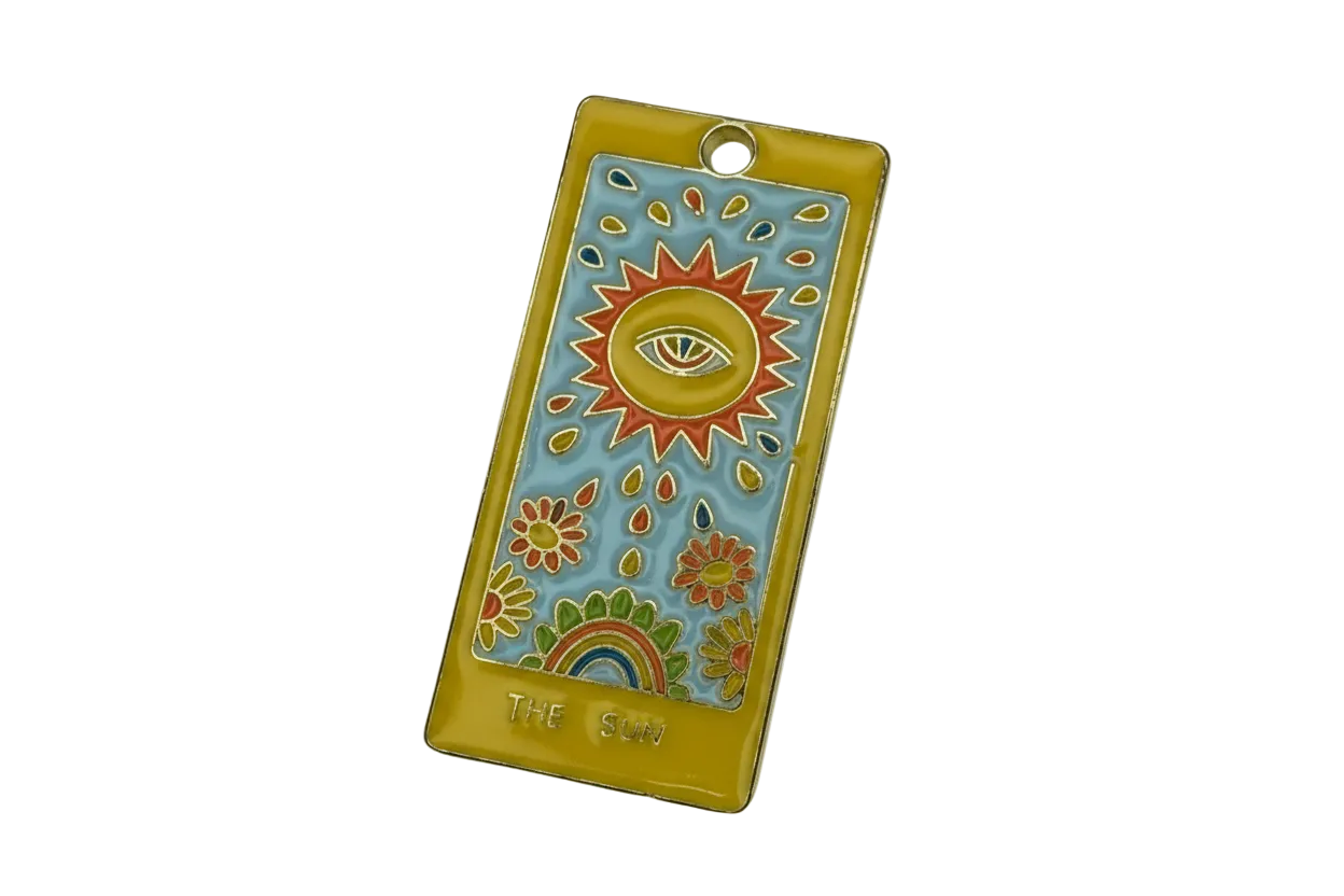 Gold-edged enamel tarot card with sun and eye motif on sky-blue background, with flowers and rainbow