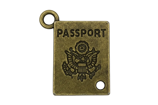 Antique gold miniature passport book charm with engraved "PASSPORT" lettering and crest