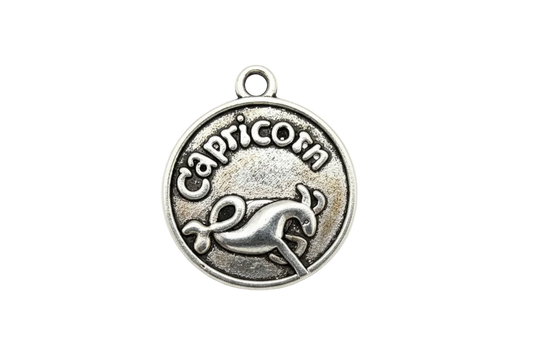 Antiqued silver round Capricorn medallion with raised lettering and sea-goat symbol