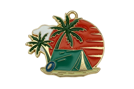 Gold-outlined enamel camping scene with green tent and palm trees on a red sunset backdrop