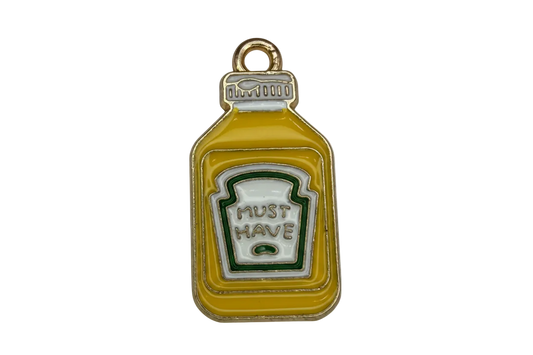 Mustard-yellow sauce bottle charm with white label and green outline in gold-tone metal