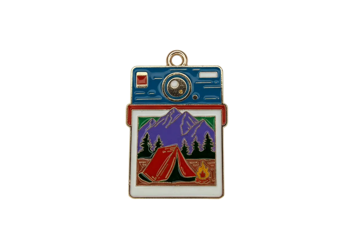 Gold-trimmed enamel instant camera with mountain camping photo, red tent, pine trees, and campfire