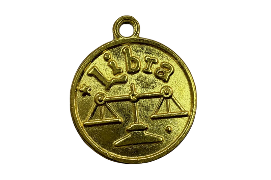 Round gold Libra coin with embossed scales symbol and raised lettering