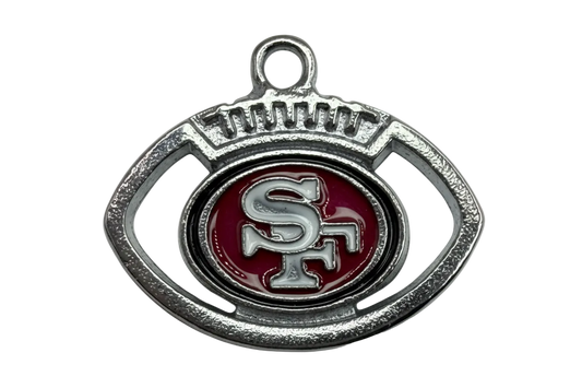 Silver football-shaped emblem with red enamel center and raised monogram detail