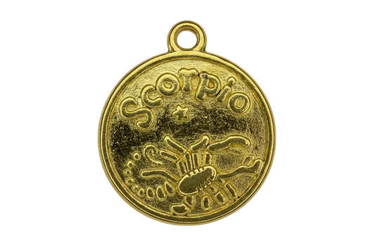Round gold coin medallion with embossed scorpion and Scorpio lettering