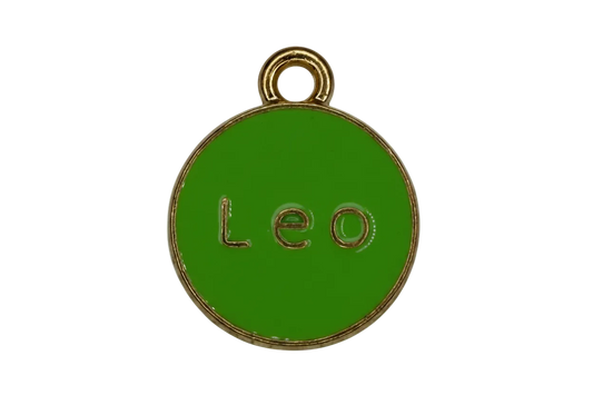 Glossy green round enamel disc with gold rim and raised “Leo” lettering