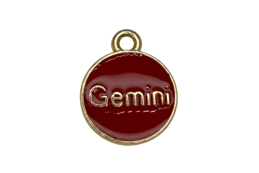 Glossy red enamel round disc with gold border and raised Gemini lettering