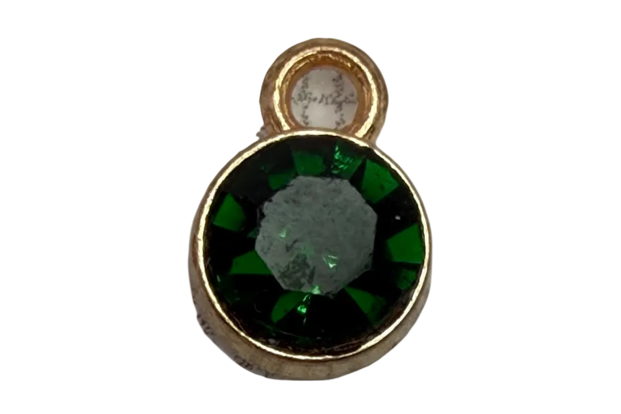 Faceted deep green round gem framed in gold