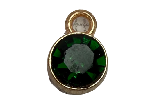 Faceted deep green round gem framed in gold