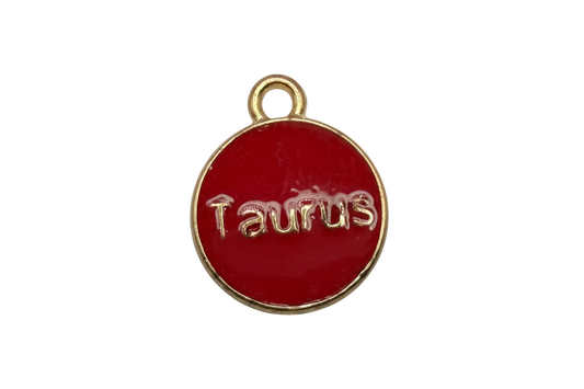 Glossy red round disk with raised gold Taurus lettering and gold rim