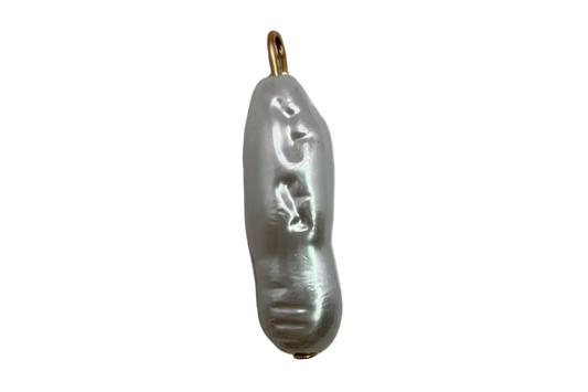 Elongated baroque pearl with carved face detail and gold accents on black background