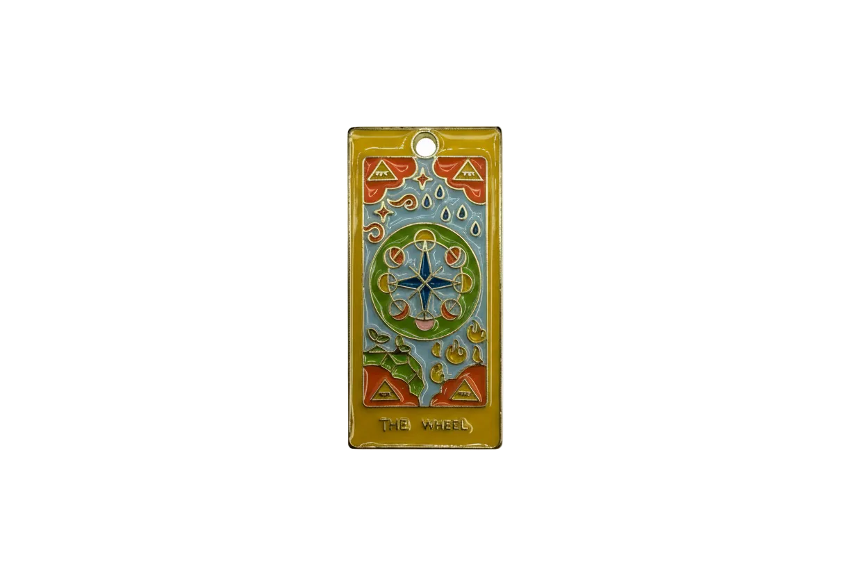 Gold tarot card charm with enamel wheel motif and “THE WHEEL” text
