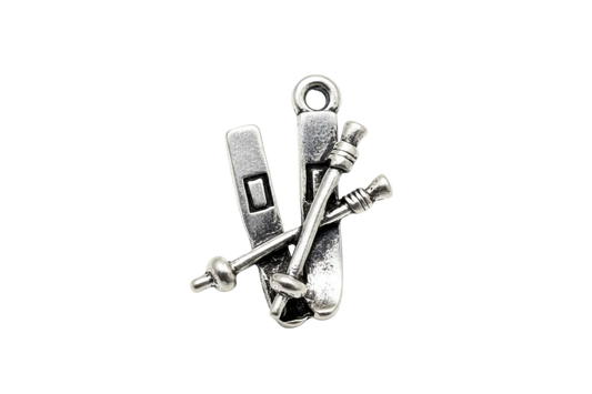 Antique silver ski set with crossed poles, vintage metal finish