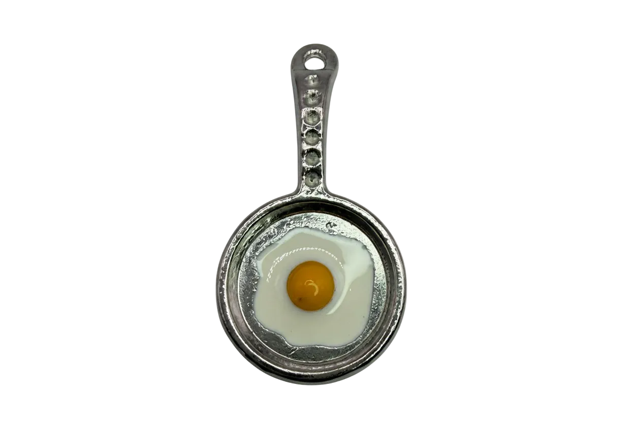 Silver skillet charm with a glossy sunny-side up egg, white enamel and yellow yolk