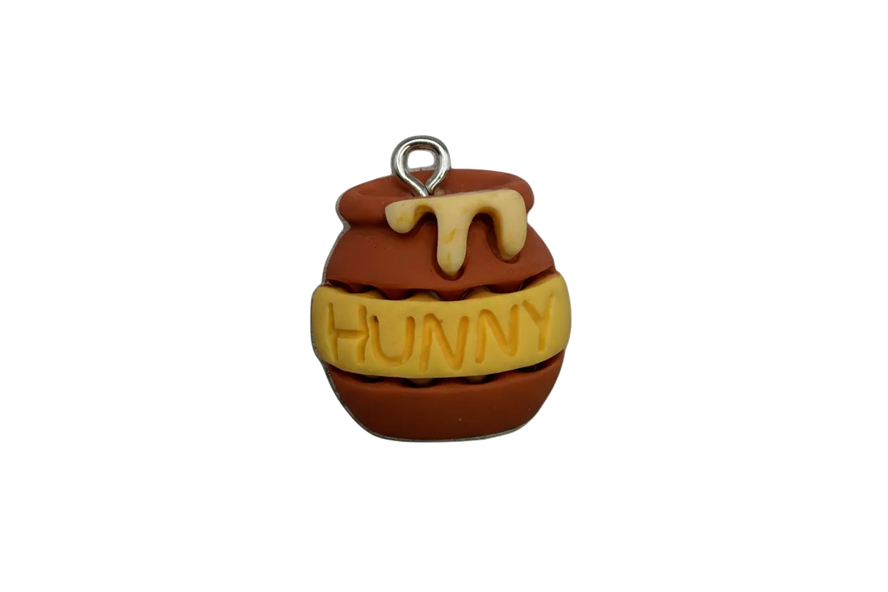 Brown honey pot with cream drip and yellow band reading “HUNNY,” silver-toned top