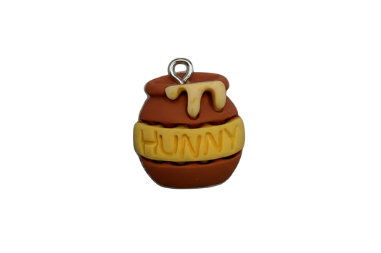 Brown honey pot with cream drip and yellow band reading “HUNNY,” silver-toned top