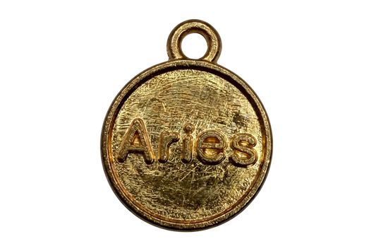 Round gold zodiac coin with raised Aries lettering and textured finish