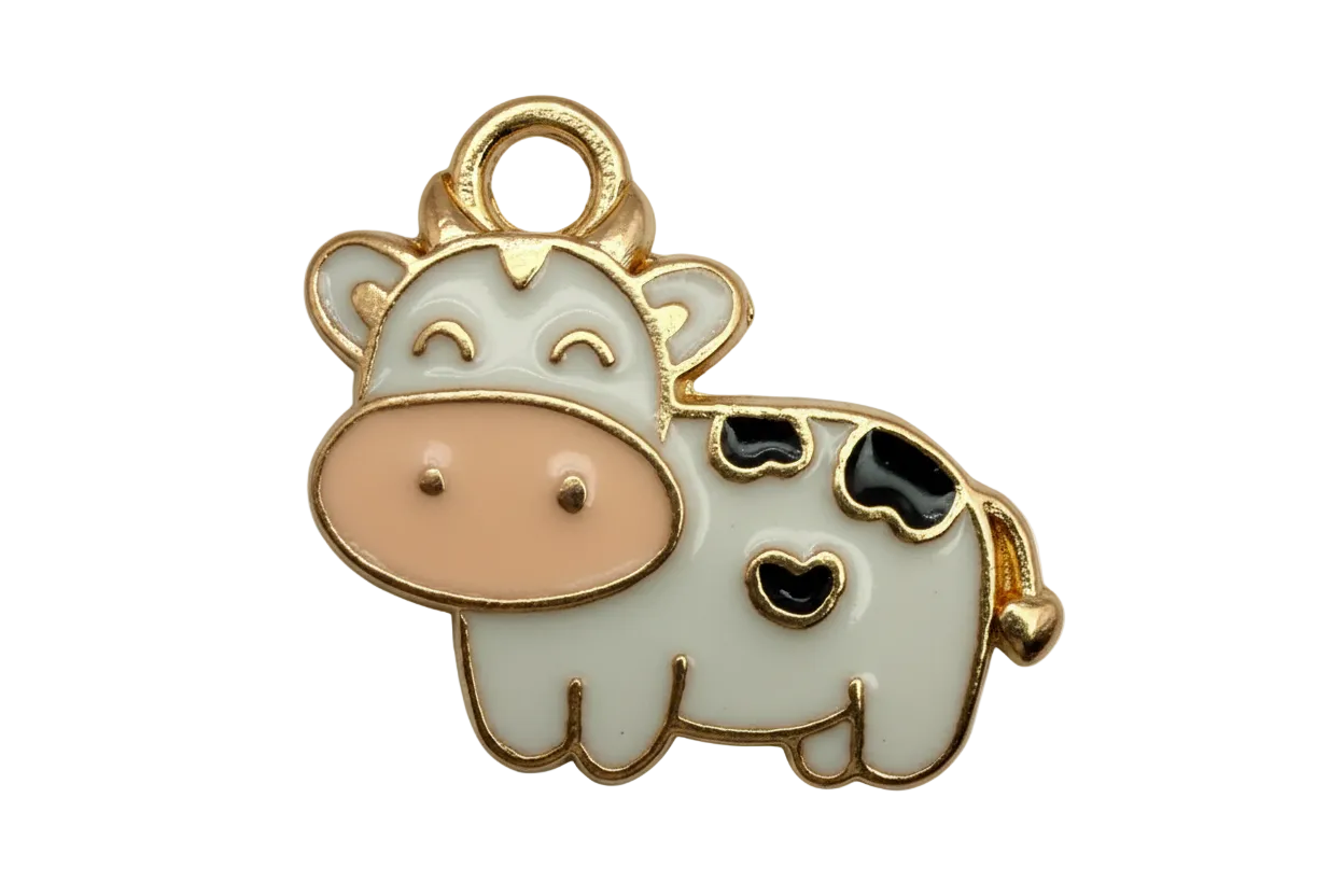 Gold-outlined enamel cow with white body, black spots, and blush pink snout