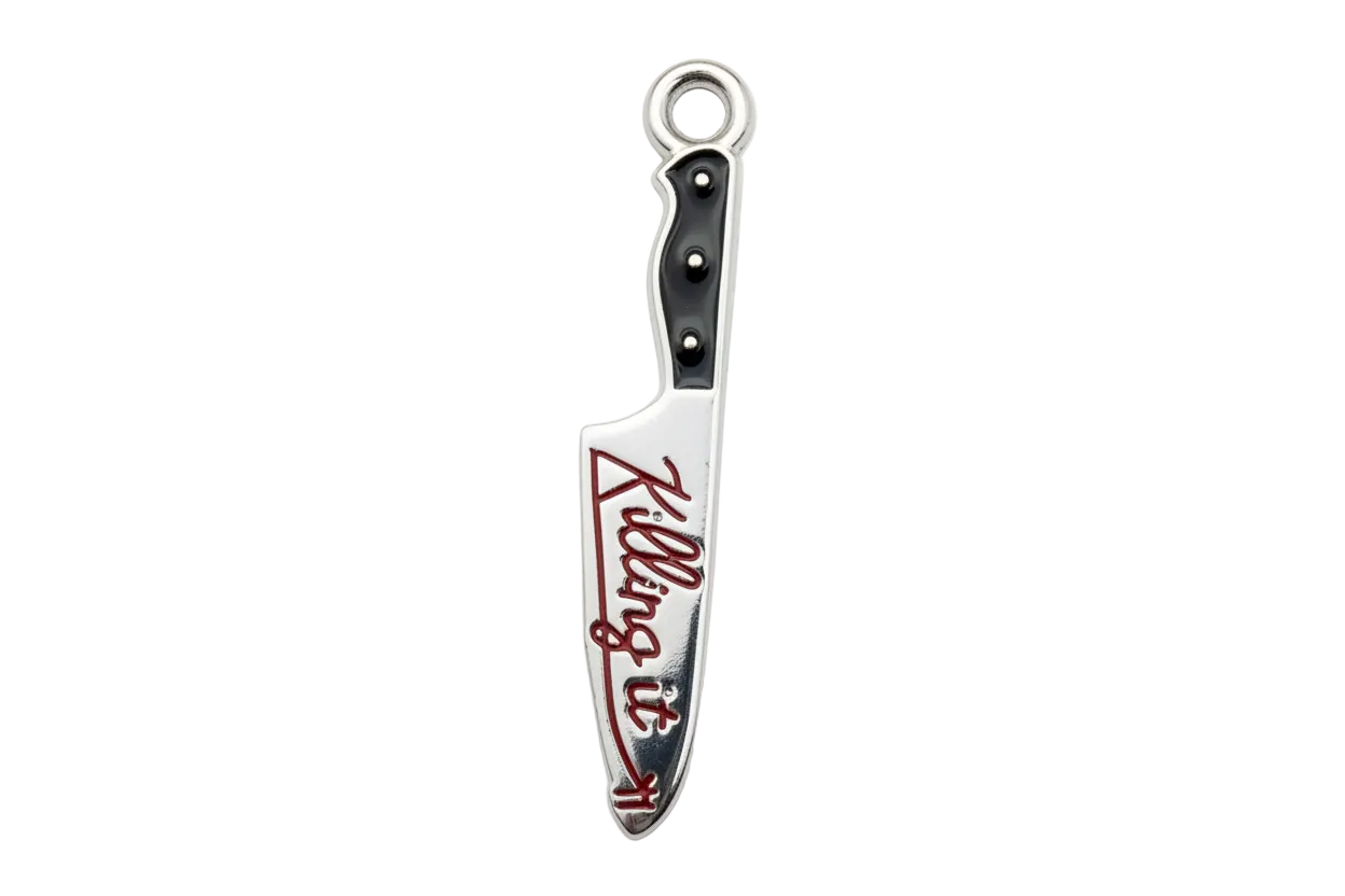 Polished silver knife charm with black handle and red script enamel detail