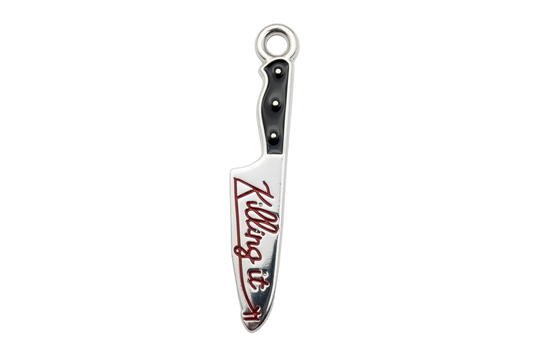 Polished silver knife charm with black handle and red script enamel detail