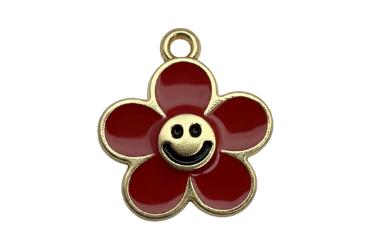 Gold-outlined red enamel flower with a smiley face center and a small clear gem accent