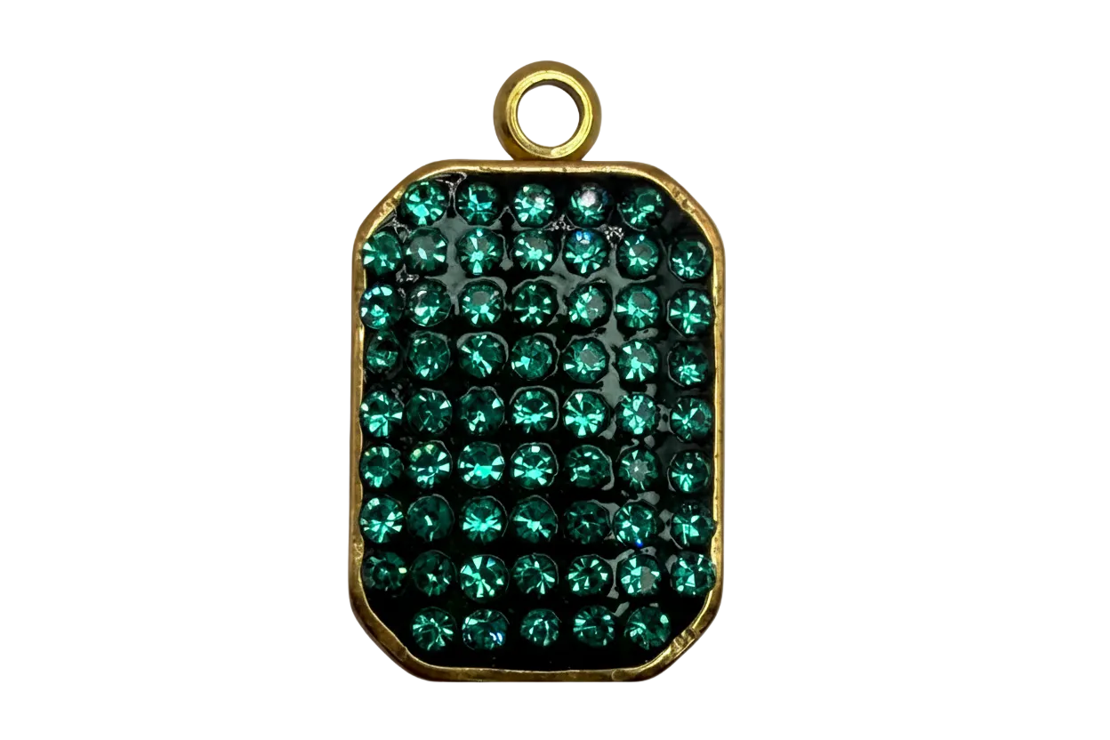 Gold-framed rounded rectangle plate with pavé emerald green crystals over a glossy black base