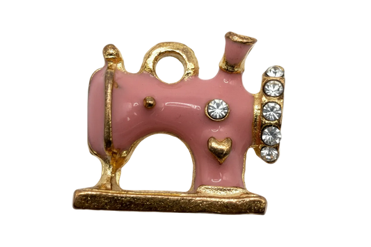 Pink enamel sewing machine with gold trim, heart detail, and clear crystals