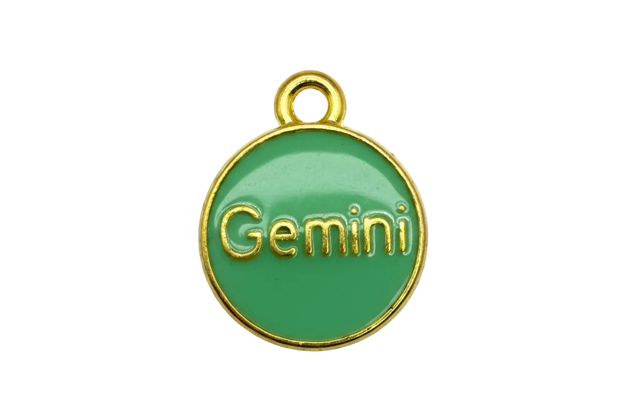 Green enamel round zodiac disk with raised gold Gemini lettering and gold rim