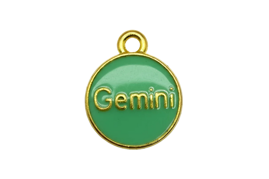 Green enamel round zodiac disk with raised gold Gemini lettering and gold rim