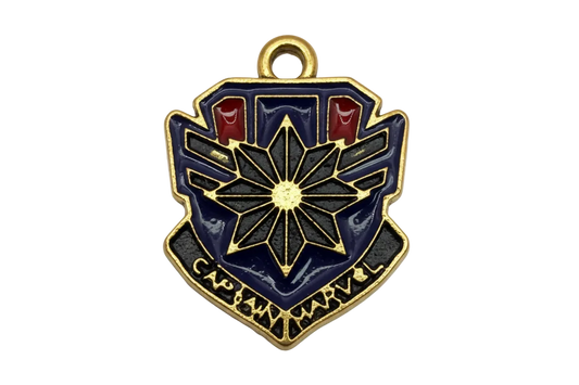 Gold-tone shield emblem with navy enamel, black starburst center, and small red accents