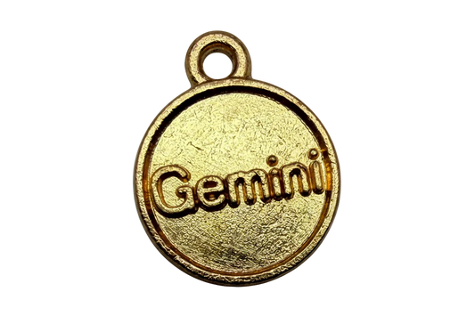 Round gold disc with raised Gemini lettering and textured finish