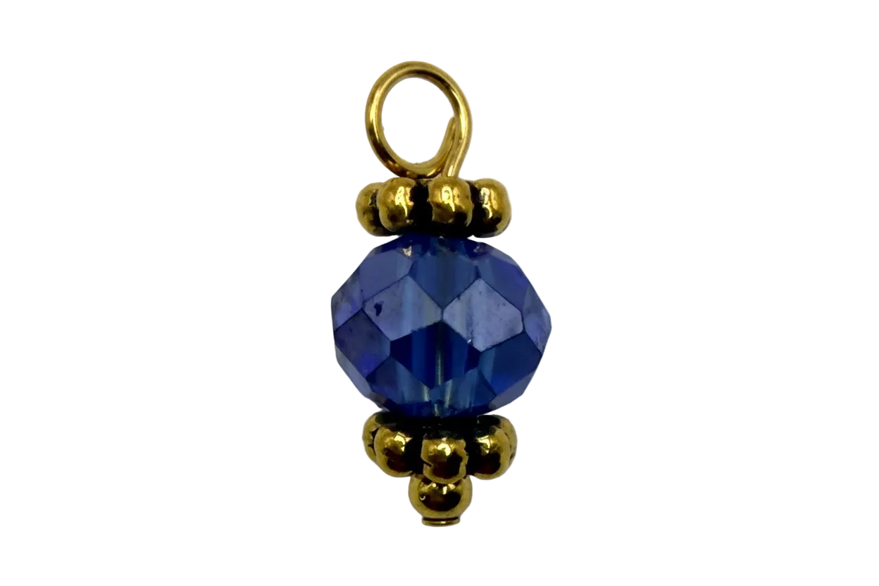Faceted sapphire blue orb gem with gold bead accents on black background