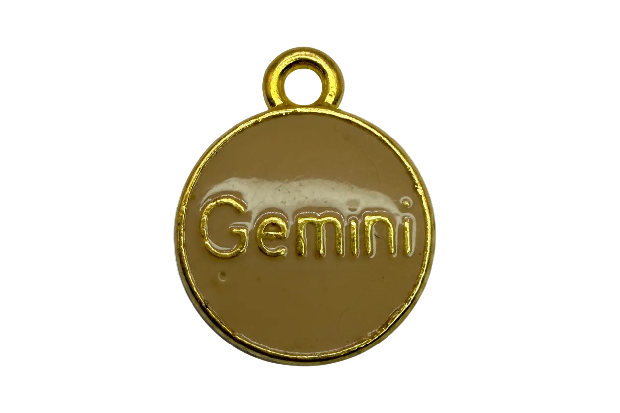 Round tan enamel disc with raised gold Gemini lettering and gold border