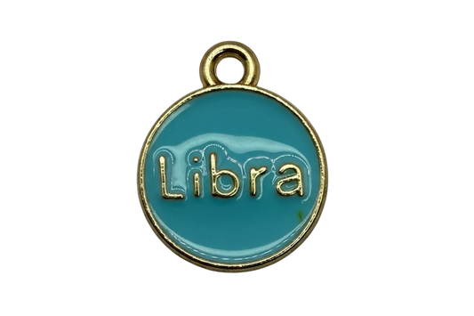 Teal round zodiac disc with raised gold Libra lettering and a gold rim