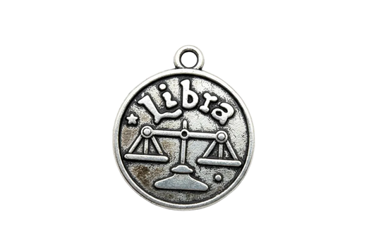 Round antique silver Libra zodiac coin with raised scales symbol and "Libra" text