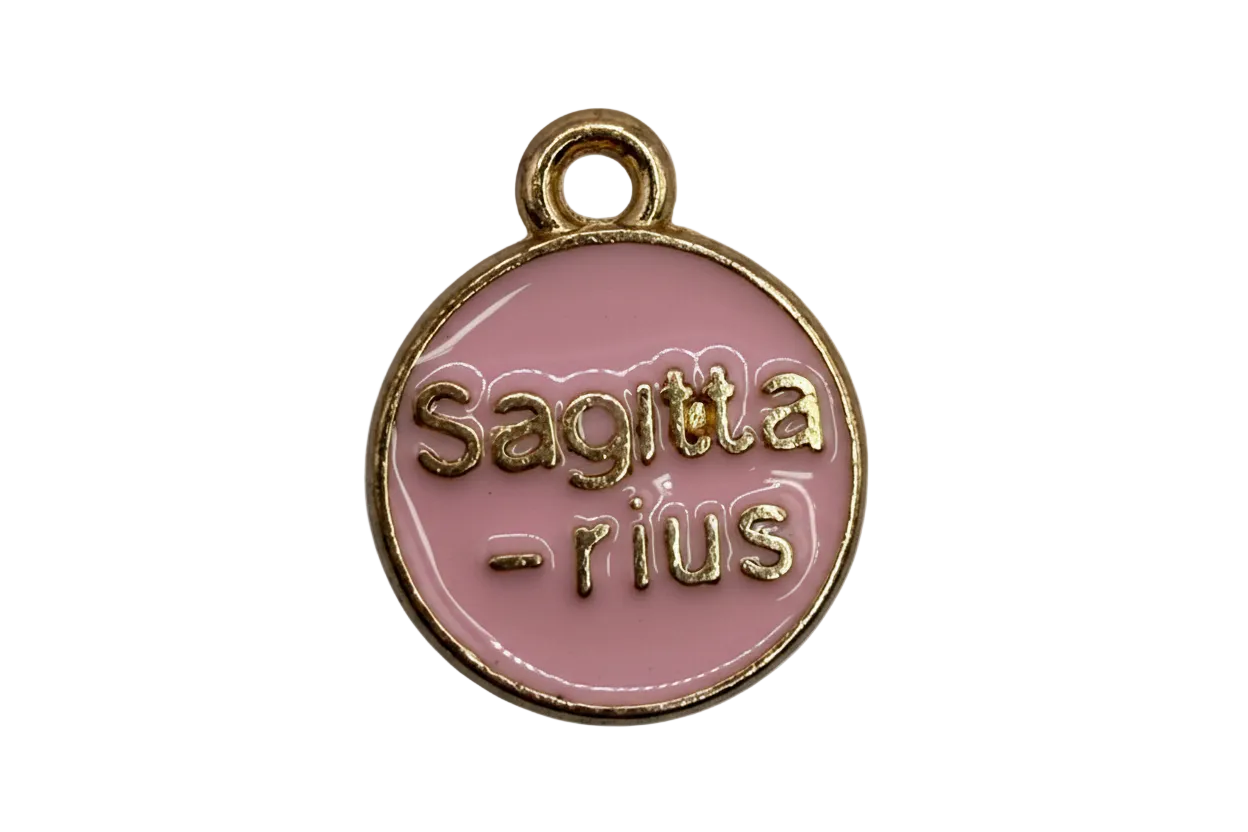 Round pink enamel zodiac coin with raised gold “Sagittarius” and “sun” lettering