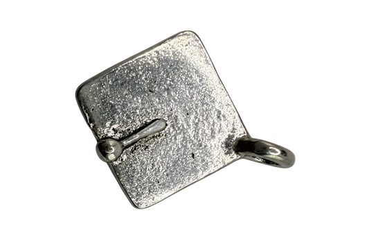 Textured silver-tone suitcase charm with a vintage finish on black background