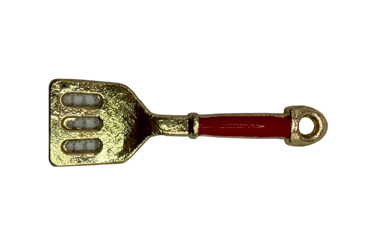 Gold spatula charm with glossy red handle and three cutout slots