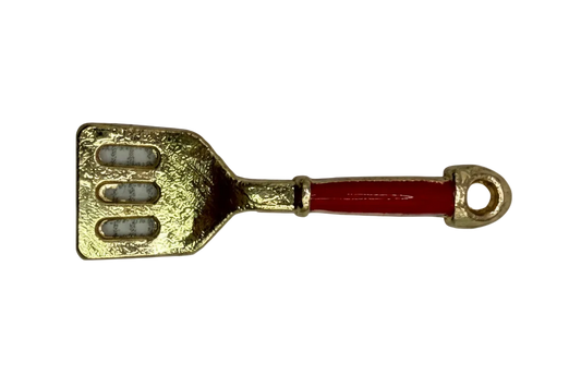 Gold spatula charm with glossy red handle and three cutout slots