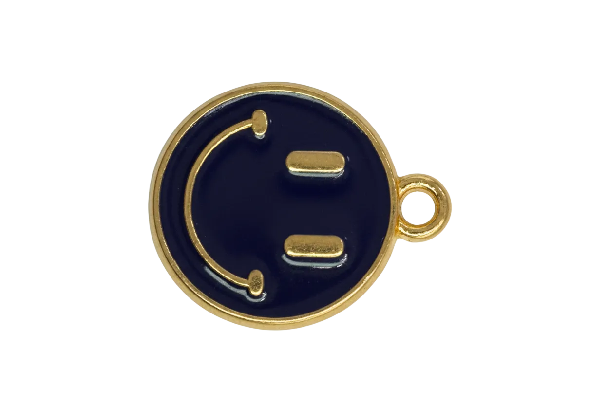 Navy enamel winking face coin in gold with a small clear crystal accent