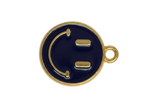 Navy enamel winking face coin in gold with a small clear crystal accent