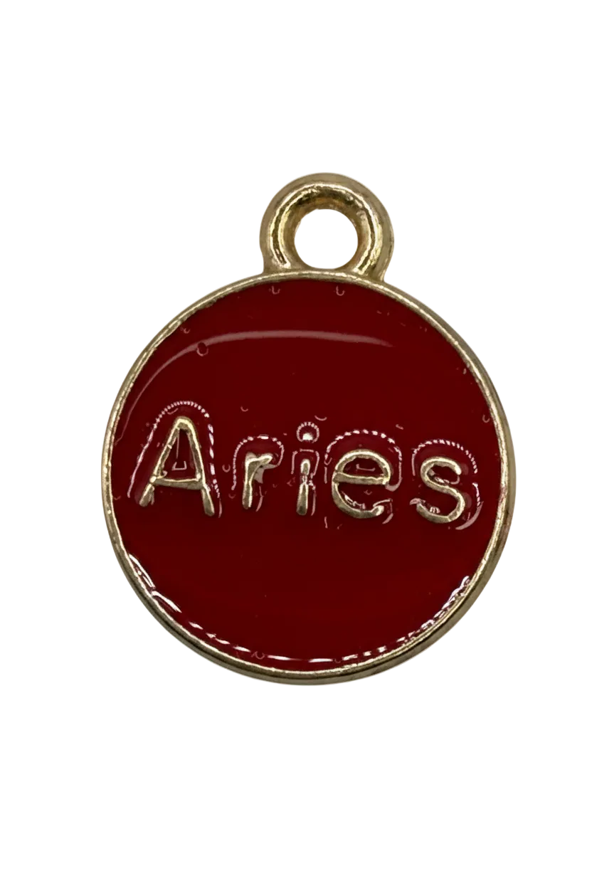 Round red enamel Aries zodiac disc with raised gold lettering and a small clear gem accent