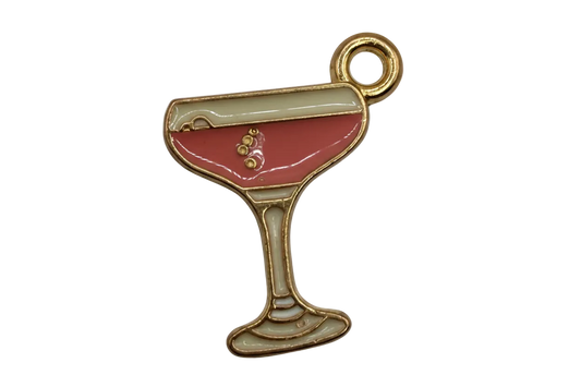 Gold-tone cocktail glass charm with pink enamel drink and ivory accents