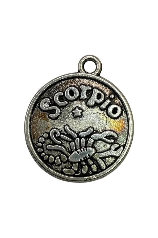Antique silver round Scorpio zodiac disc with raised scorpion symbol and star detail