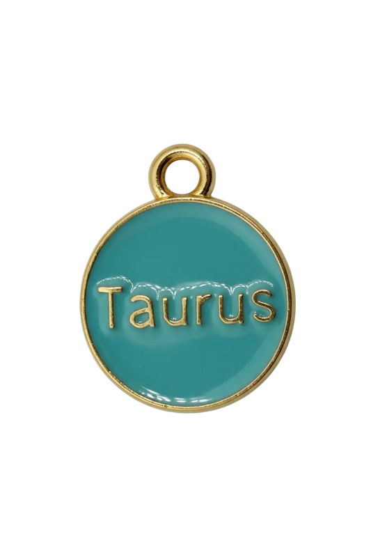 Teal round Taurus zodiac medallion with raised gold lettering and a small white gem accent