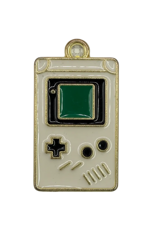 Cream and black enamel handheld game console with green screen and gold outline