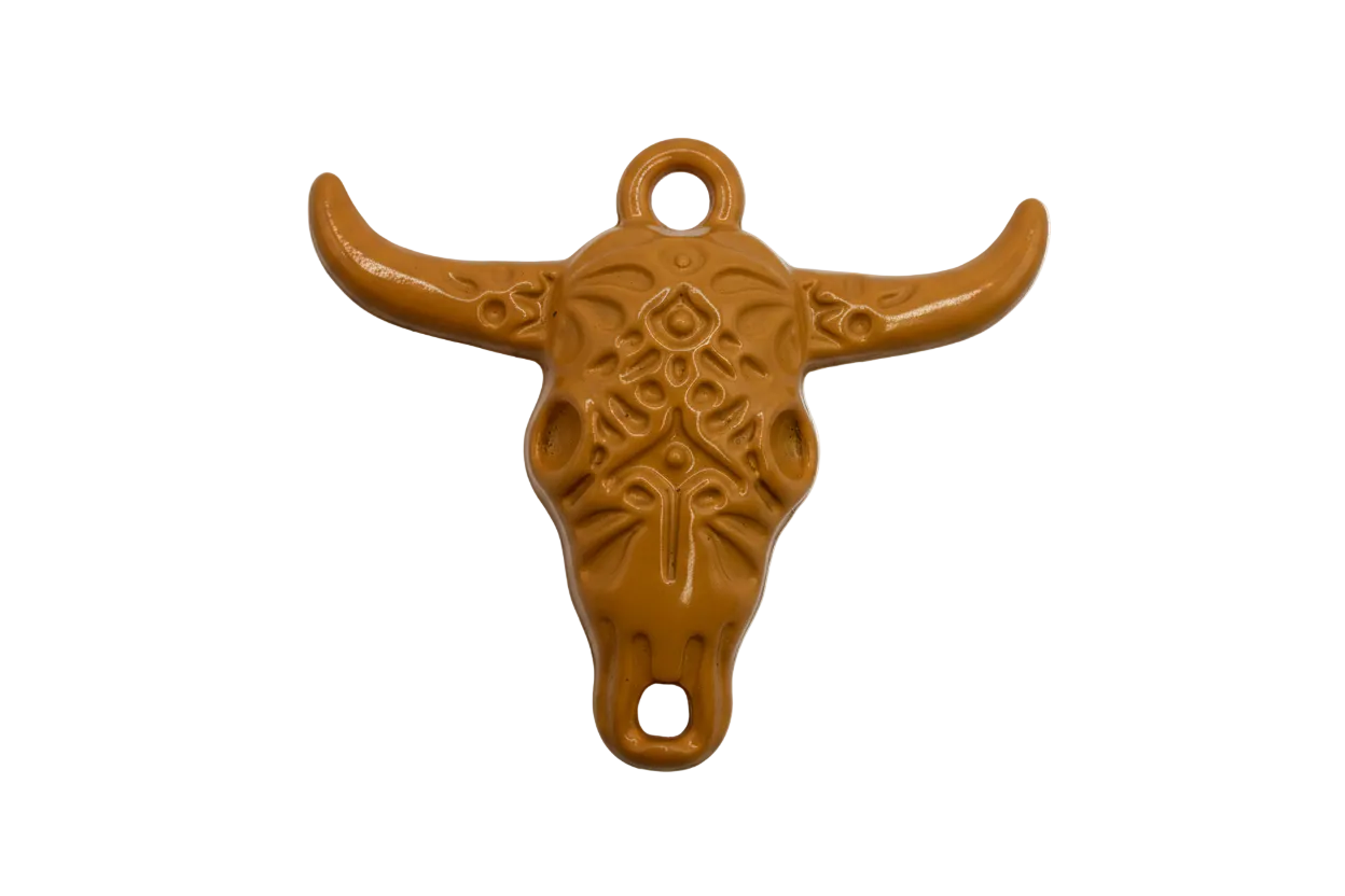Caramel-brown longhorn skull charm with embossed tooled pattern, gold-toned metal base