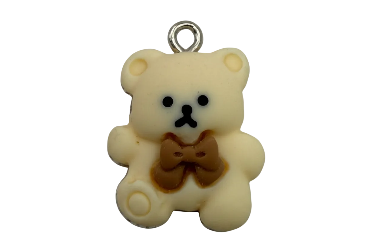 Ivory teddy bear charm with brown bow and black facial details, silver top